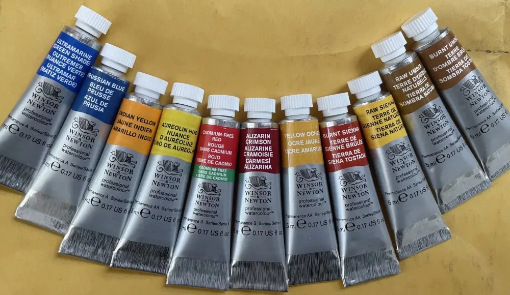 Tubes of Winsor and Newtonw watercolor paint laid in an arch