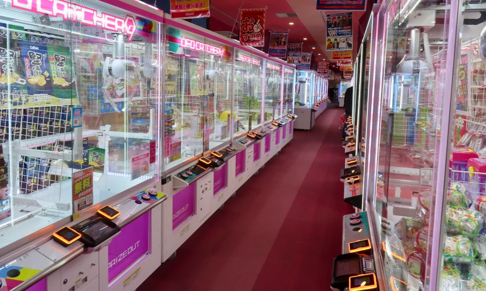 View inside an arcade where row after row of brightly lit claw machines offer prizes to win or try to win