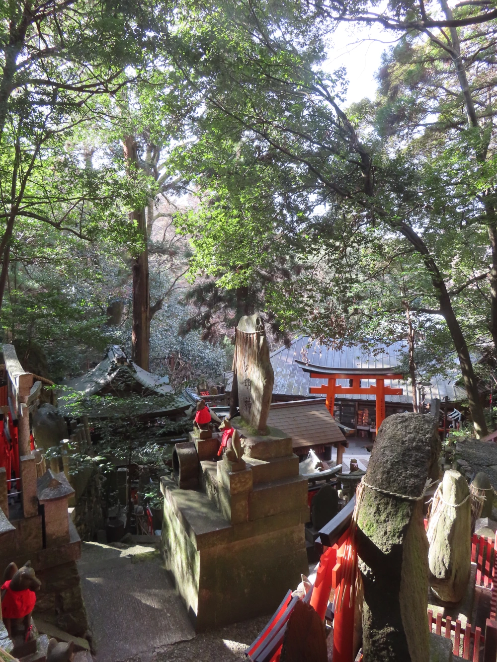 Stone shrines in dappled sunlight and trees above