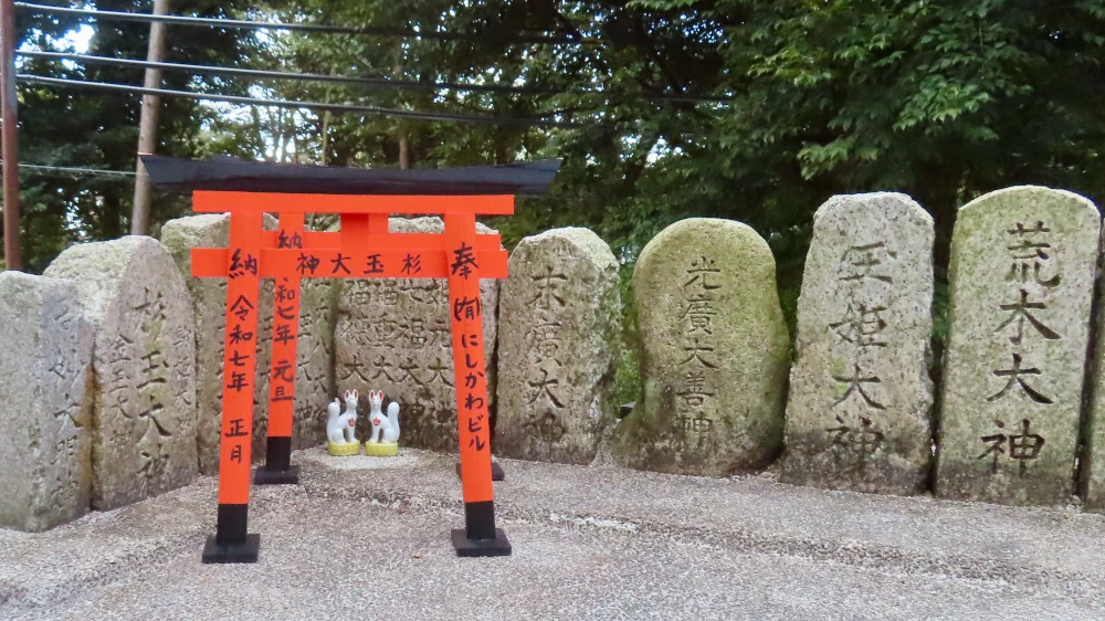 A very small torii with tiny ceramic foxes